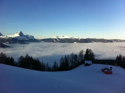 a view of a snow covered mountain with a layer of clouds at Casa Gogn in San Vigilio Di Marebbe