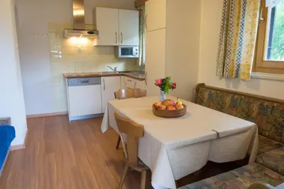 a kitchen with a table with a bowl of fruit on it at Ciasa Torneri in San Vigilio Di Marebbe