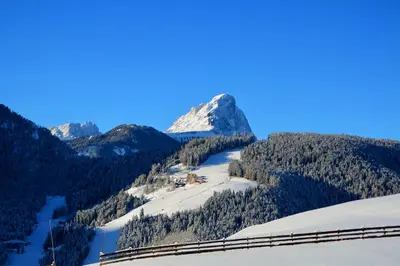 a view of a snowy mountain with a train at Cone da Val in San Vigilio Di Marebbe