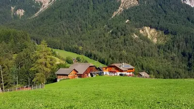 a house on a hill in a green field at Cone da Val in San Vigilio Di Marebbe