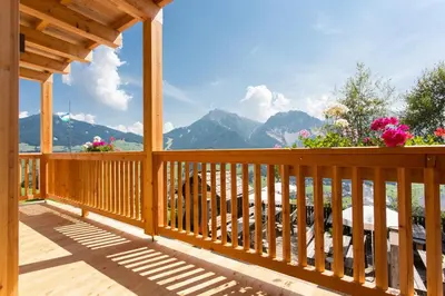a wooden deck with a view of the mountains at Agriturismo Soleseid in San Vigilio Di Marebbe