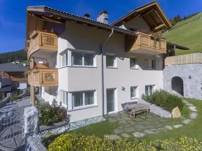 a large white building with wooden balconies and a bench at Messnerhof, Durnholz in Valdurna