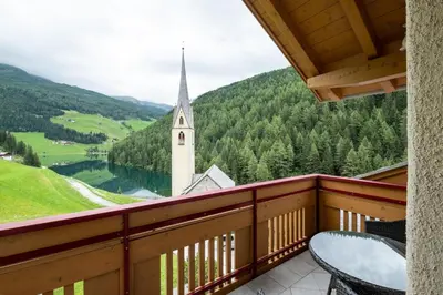 a balcony with a view of a church at Messnerhof, Durnholz in Valdurna