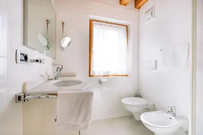 a white bathroom with a sink and a toilet at Residence Alpenrose in Rasùn di Sotto