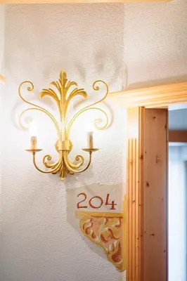a chandelier hanging on a wall in a room at Residence Alpenrose in Rasùn di Sotto