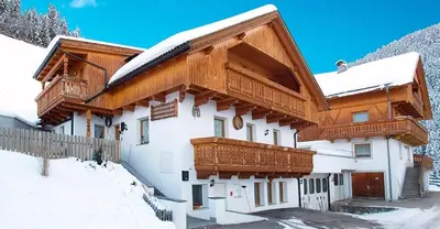 a house with snow on the roof of it at Pinterhof in San Vigilio Di Marebbe