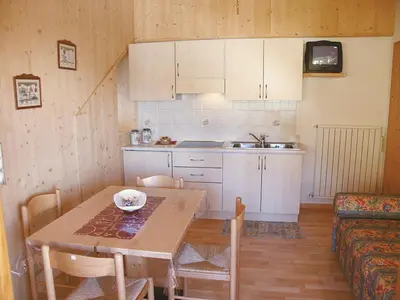a kitchen and dining room with a table and a couch at Pinterhof in San Vigilio Di Marebbe