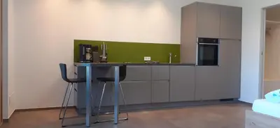 a kitchen with a table and a green wall at Pomaria in Caldaro