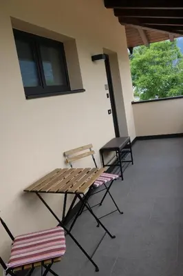 a patio with chairs and a wooden table and chairs at Pomaria in Caldaro