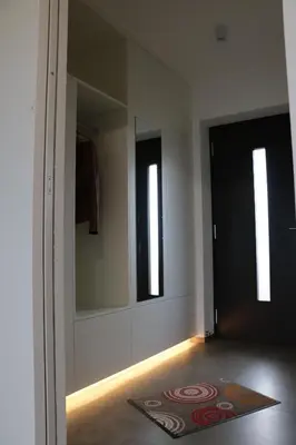 a hallway with a door with a rug and a mirror at Pomaria in Caldaro