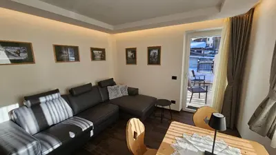a living room with a couch and a table at Casa Il Giardino in Pozza di Fassa