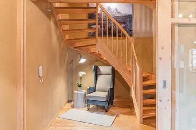 a room with a staircase and a chair in a house at Eco Chalet Olival in Braies