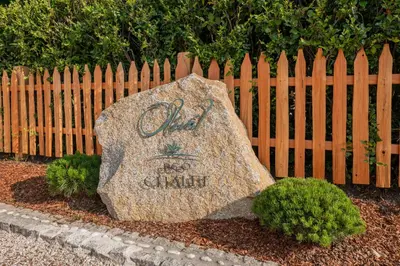 a rock sitting in front of a wooden fence at Eco Chalet Olival in Braies