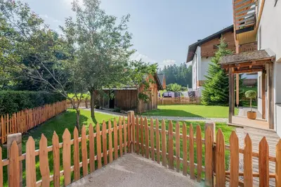 a wooden fence in front of a house at Eco Chalet Olival in Braies