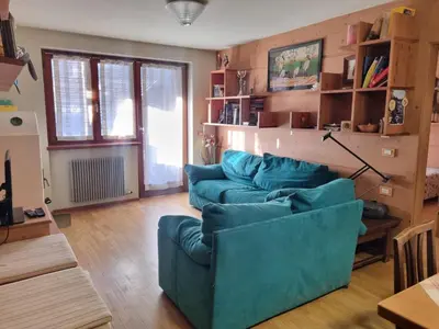 a living room with two blue couches in it at Col Rodella - Canazei in Canazei