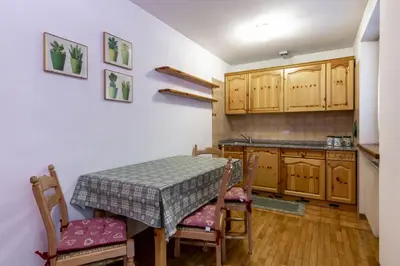 a kitchen with a table and chairs in a room at Col Rodella - Canazei in Canazei