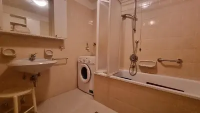 a bathroom with a sink and a washing machine at Col Rodella - Canazei in Canazei