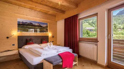 a bedroom with a bed and a large window at Villa Anita San Vigilio di Marebbe in San Vigilio Di Marebbe