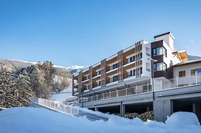 a building with snow in front of it at Hotel Torgglerhof in Bressanone