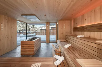 an indoor sauna with wooden walls and wooden floors at Hotel Torgglerhof in Bressanone