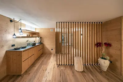 a kitchen with wooden walls and a wooden floor at Hotel Torgglerhof in Bressanone