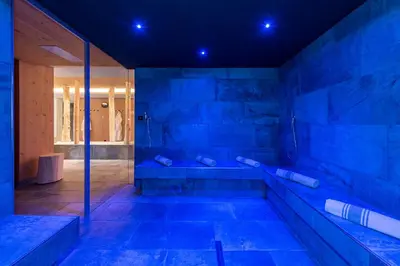 a large bathroom with a tub with blue lighting at Hotel Torgglerhof in Bressanone