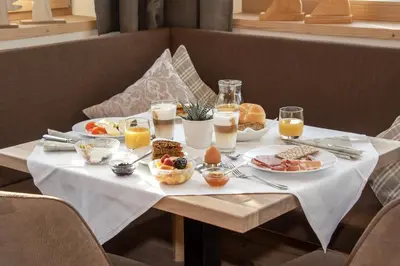 a table with breakfast foods and drinks on it at Hotel Torgglerhof in Bressanone