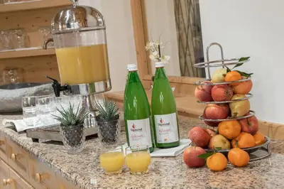 a counter with two bottles of orange juice and fruit at Hotel Torgglerhof in Bressanone