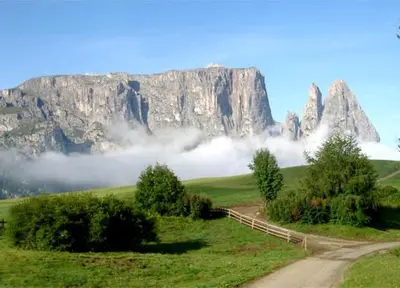 a road in a field with a mountain in the background at Pension Hofer in Brunico