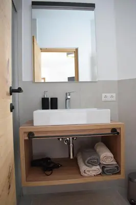 a bathroom with a sink and a mirror and towels at Pension Hofer in Brunico