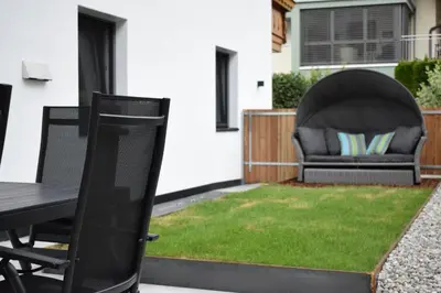 a patio with a table and a chair at Pension Hofer in Brunico