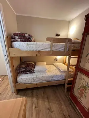 a bedroom with a bed and a table with a plate of cookies at Case Vacanza Marco - Apt 115 in San Martino di Castrozza