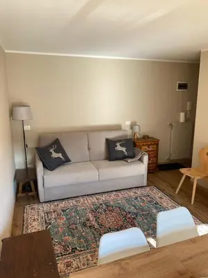a living room with a table with a plate of food on it at Case Vacanza Marco - Apt 115 in San Martino di Castrozza