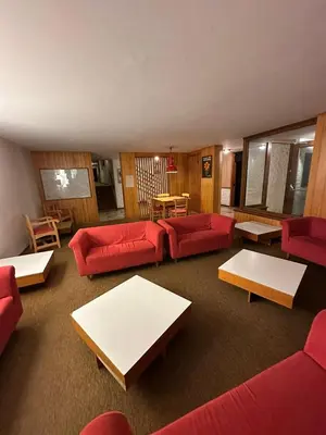a large white building with mountains in the background at Case Vacanza Marco - Apt 115 in San Martino di Castrozza