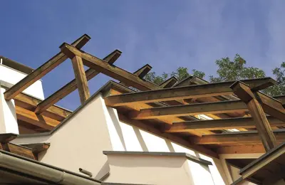 a wooden pergola on the side of a building at Residence Haus Kalterersee in Caldaro