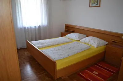 a bedroom with a bed with a wooden headboard at Ferienwohnung Winklerhof in Lana