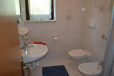a bathroom with a sink and a toilet at Ferienwohnung Winklerhof in Lana