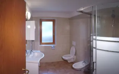 a bathroom with a toilet and a sink and a shower at Residencesora in San Vigilio Di Marebbe