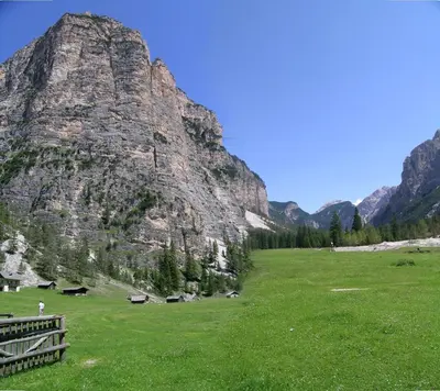 a large grassy field with a mountain in the background at Residencesora in San Vigilio Di Marebbe