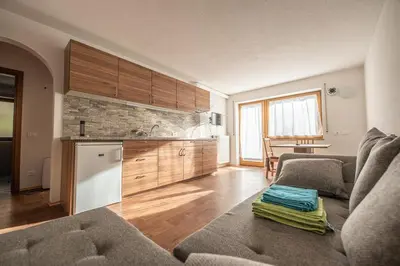 a living room with a couch and a kitchen at Residencesora in San Vigilio Di Marebbe