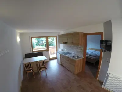 a kitchen with a sink and a table in a room at Residencesora in San Vigilio Di Marebbe