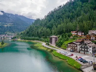 a view of a river in a town with mountains at Condominio al Lago in Alleghe