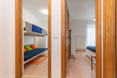 a small room with a bunk bed and a bedroom at Condominio al Lago in Alleghe