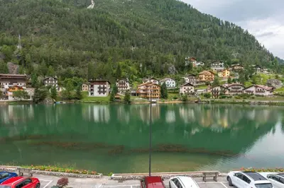 a lake in front of a town with houses at Condominio al Lago in Alleghe