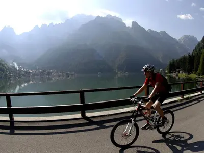 a man riding a bike on a mountain road at Condominio al Lago in Alleghe
