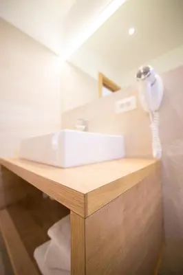 a bathroom sink with a hair dryer on a counter at Residence Grünwald in San Martino