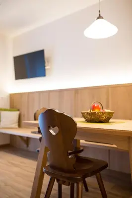 a chair in front of a table with a bowl of fruit at Residence Grünwald in San Martino