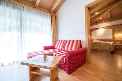 a living room with a red couch and a table at Hotel Jager Hans in San Martino
