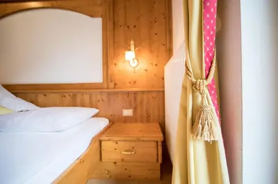a bedroom with a bed and a curtain at Hotel Jager Hans in San Martino