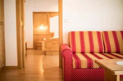 a living room with a red couch and a table at Hotel Jager Hans in San Martino